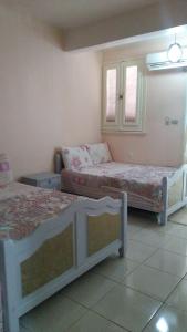 a bedroom with two beds and a couch in it at الساحل الشمالي in Borg El Arab