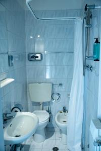 La salle de bains blanche est pourvue de toilettes et d'un lavabo. dans l'établissement SOMA, à Rimini