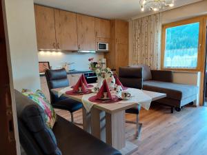 a kitchen and living room with a table and chairs at Ferienwohnungen Rupertihaus in Flachau