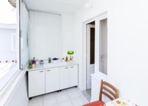 a kitchen with white cabinets and a window at Apartment Vukoja in Dubrovnik