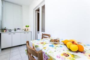 a kitchen with a table with a plate of fruit on it at Apartment Vukoja in Dubrovnik