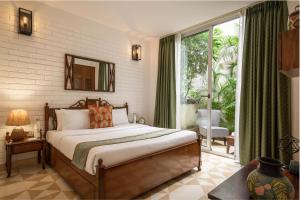 a bedroom with a bed and a large window at El Arbol by The Blue Kite with Rooftop Pool, Kitchen, Wifi, Security,10 Mins to Candolim Beach & 5 mins to Casino in Panaji
