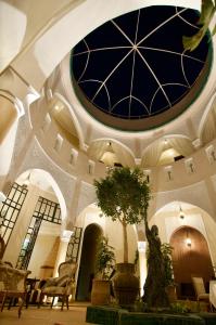 a building with a ceiling with a tree in it at La Claire Fontaine in Marrakesh