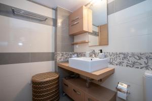 a bathroom with a sink and a mirror at Villa Linda in Tolo +12 photos