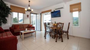 a living room with a table and chairs and a couch at Villa Linda in Tolo