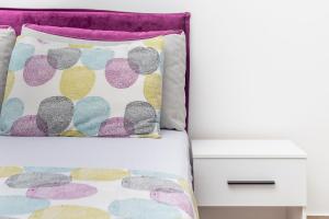 un letto con un cuscino colorato e un comodino di Studio apartman Scardona a Kotor (Cattaro)