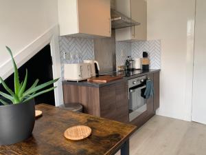 uma cozinha com uma mesa de madeira e uma bancada em Lovely 2 Bedroom Apartment in Central Location em Greenock