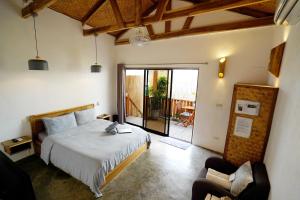 a bedroom with a bed and a sliding glass door at Fisheye The Rooms - Room 1 in El Nido