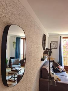 a bedroom with a mirror and a bed and a chair at APP' ART CENTRE PLAGE + PARKING GRATUIT in Collioure