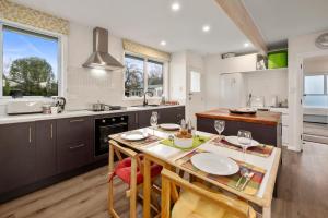 a kitchen with a table with chairs and a dining room at Plum Tree Cottage - Turangi Holiday Home in Turangi