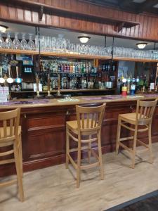 a bar with two chairs and a counter with drinks at Twa Dogs Inn in Keswick