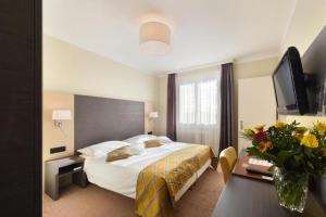 ローザンヌにあるホテル ベッレリーヴェのベッドとテレビが備わるホテルルームです。