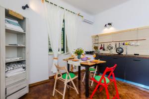 a kitchen with a table and red chairs at Apartments Eos & Vespera in Dubrovnik