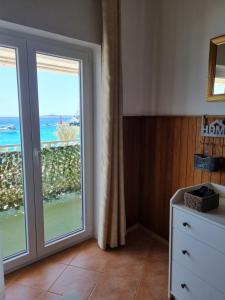 a room with a sliding glass door with a view of the ocean at APARTMAN SMOLJIC 4+2 in Primošten