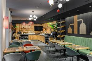 a restaurant with tables and chairs and a bar at Hotel Oktogon Haggenmacher by Continental Group in Budapest