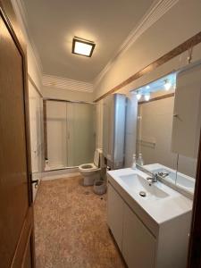 a bathroom with a white sink and a toilet at Penthouse Ocean View Sesimbra - parking @center in Sesimbra +11 photos