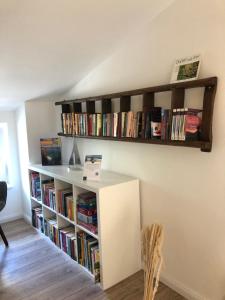 a book shelf filled with books on a wall at Landhaus Ankerplatz im Grünen, strandnah , fernab vom mainstream , ideal für Familien in Gorow