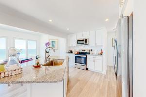 a kitchen with white cabinets and a stainless steel refrigerator at Waterfront Escape in Nameloc Heights