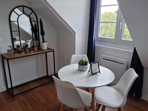 uma sala de jantar com uma mesa branca e cadeiras brancas em Studio Cosy Centre ville em Caen