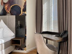 ein Hotelzimmer mit einem Schreibtisch und einem Bett in der Unterkunft Schlosshotel Brilon-Wald in Brilon-Wald