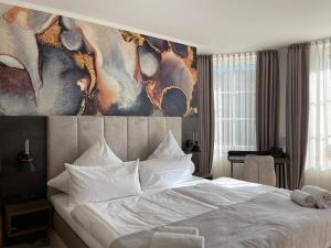 1 dormitorio con 1 cama blanca y una pintura en la pared en Schlosshotel Brilon-Wald en Brilon-Wald