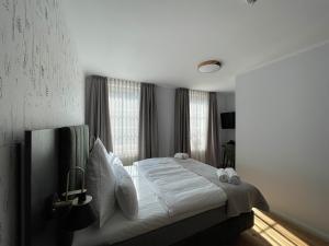 um quarto com uma cama com lençóis brancos e almofadas em Schlosshotel Brilon-Wald em Brilon-Wald