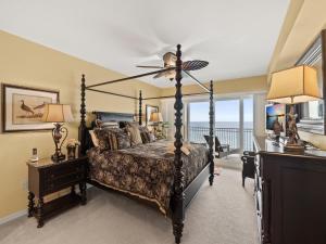 a bedroom with a bed with a fan and a balcony at La Vistana 703 in St Pete Beach