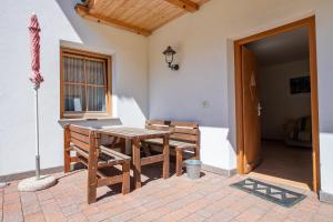 a patio with a table and two chairs and an umbrella at Apartments Berdan in Santa Cristina Gherdëina
