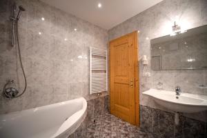 a bathroom with a tub and a sink and a bath tub at Apartments Berdan in Santa Cristina Gherdëina +16 photos