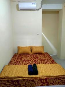 a bed with two pairs of shoes sitting on it at SPOT ON 91402 Home'59 Tegal Danas in Bekasi