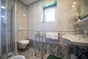 łazienka z toaletą i umywalką w obiekcie Apartments Seida w mieście Selva di Val Gardena +37 zdjęć