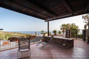 twee stoelen op een patio met de oceaan op de achtergrond bij Dammuso Rosa in Pantelleria