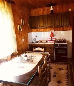 a kitchen with a table with chairs and a stove at Seoska kuća Jela in Nova Varoš