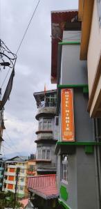 a building with an orange sign on the side of it at Hotel Nindik in Gangtok
