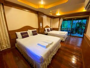 Una habitación de hotel con dos camas y balcón. en Morning Star Resort, en Baan Tai 86 fotos más