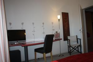 a room with a desk with a television and two chairs at Hotel am Fluss in Neuburg an der Donau