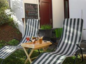 
a picnic table with chairs and a lawn chair at Hotel am Fluss in Neuburg an der Donau

