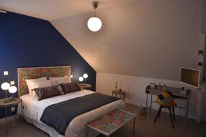 a bedroom with a large bed and a blue wall at Epicurieux Normand in Viessoix