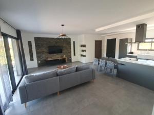 a living room with a couch and a kitchen at Villa l'alivu in Afa