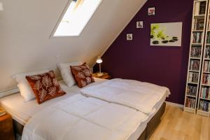 - une chambre mansardée avec un grand lit dans l'établissement Appartement op de 1e verdieping., à Wemeldinge