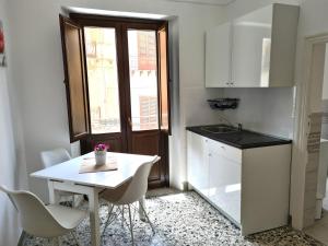 a small kitchen with a white table and chairs at Casa Lara in Castellammare del Golfo