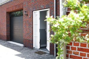 un bâtiment en briques avec une porte et un garage dans l'établissement Appartement op de 1e verdieping., à Wemeldinge