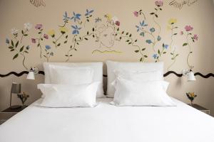 Un dormitorio con una cama con flores en la pared. en Hôtel Arvor Saint Georges, en París