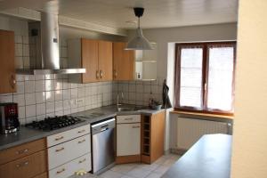 a kitchen with a sink and a stove top oven at Spacieux gîte jusqu'à 12 personnes in Ammerschwihr