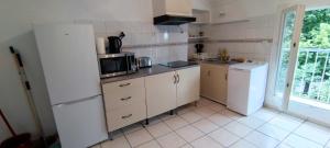 uma cozinha com um frigorífico e um micro-ondas em Appartement 45 m² proche du centre ville em Lunel