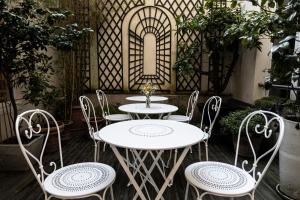 Un grupo de mesas y sillas en un patio. en Hôtel Arvor Saint Georges, en París