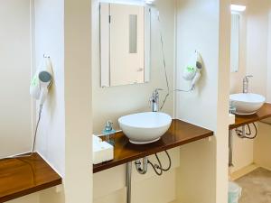 a bathroom with two sinks and a mirror at Housei in Zamami