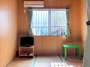 a living room with a television and a window at Housei in Zamami +39 photos