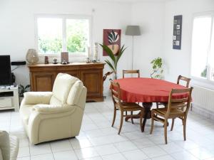 Challes的住宿－Chambres des 24h00 du Mans，客厅设有餐桌和椅子