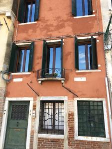 um edifício de tijolos com portas e janelas verdes em Casarossa em Veneza